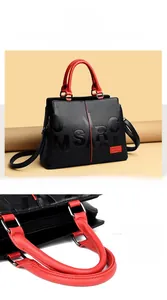 Detail of Boston style black tote with red handles and interior zipper compartments