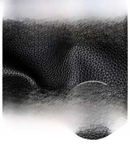 Close-up of litchi texture leather and silver bird-shaped logo on black crossbody bag