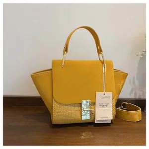 Detail of yellow vintage wing bag with smooth leather and crocodile pattern embossing