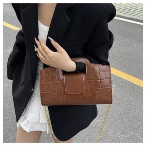 Détail du sac carré marron motif crocodile avec chaîne dorée et poignée découpée chic