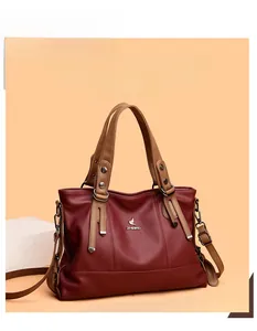 Close-up of wine red grainy leather tote bag featuring a silver metal bird logo
