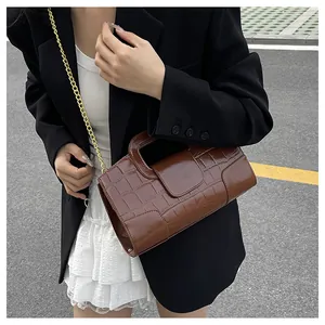 Détail du sac bandoulière marron motif crocodile avec chaîne dorée sur mannequin