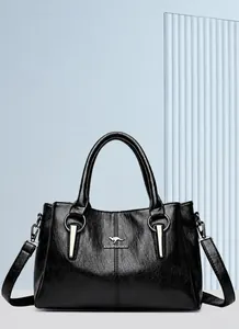 Detail der schwarzen Lederhandtasche mit Känguru-Logo aus Metall und Lychee-Struktur