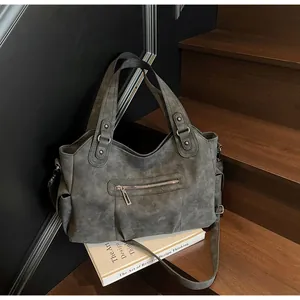 Detail of vintage grey matte tote bag showing its multiple pockets on wooden stairs