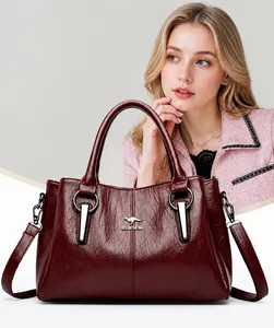 Dunkelrote Lederhandtasche mit Litschi-Struktur und Metall-Logo an einem Mode-Model gezeigt