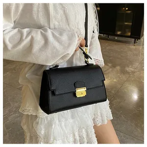 Chic black litchi pattern handbag with gold hardware and adjustable crossbody strap
