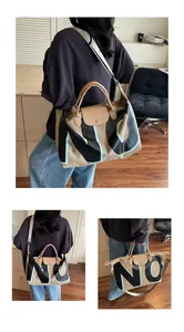 Detail of khaki large capacity travel bag featuring black NO lettering and sturdy handles
