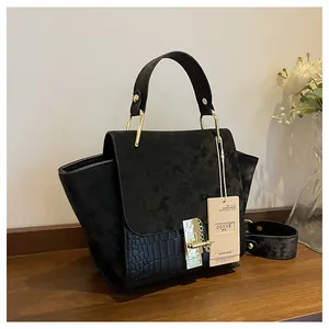 Close-up of black matte suede and crocodile texture stitching on a vintage handbag