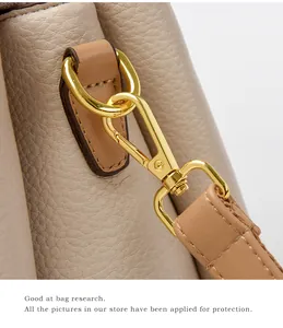 Detail of the high-quality gold hardware and lychee pattern leather on this beige handbag