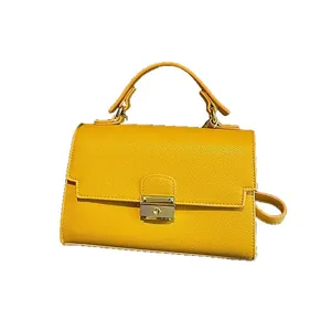 Minimalist yellow lychee grain leather handbag with gold metal lock and adjustable strap