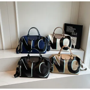 Group shot of large travel bags in four colors with leather handles and top flap closure