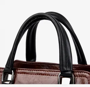 Detalle del bolso bandolera retro con textura de cuero sintético y hebilla de plata