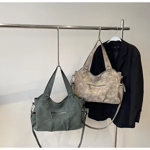 Detail of matte retro tote bags in green and beige featuring multiple utility pockets