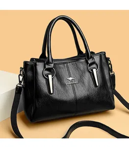 Vue détaillée du sac à main en cuir noir brillant avec logo kangourou et finitions métal