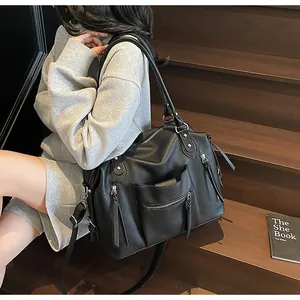 Dettaglio della borsa tote nera in pelle martellata con cerniere e tracolla regolabile