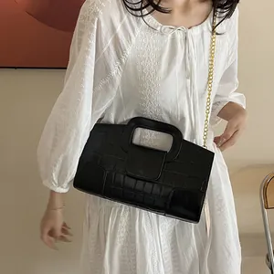 Sac à main chic noir avec motif crocodile, poignée évidée et bandoulière chaîne dorée