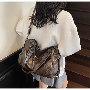 Detail of dark brown vintage faux leather tote bag with silver zippers and soft texture
