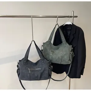 Detail of dark grey and vintage green large matte tote bags with multiple pockets