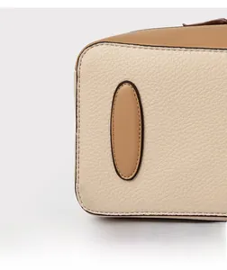 Detailed close-up of litchi grain leather bag with contrasting stitching and color blocking