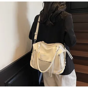 Dettaglio borsa shopper color crema con trama a grana e nappe decorative eleganti