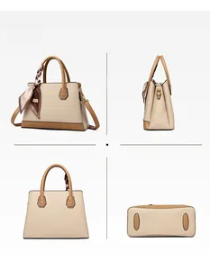 Detail view of khaki pebbled leather handbag with twin handles and silk scarf accent