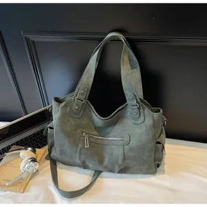 Detail view of olive green retro tote bag showing washed leather texture and side pockets