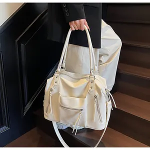 Dettaglio borsa tote bianca trama litchi con zip a nappa e finiture argentate