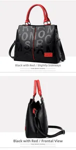 Detail of black pebbled leather handbag with red trim and embossed letter design