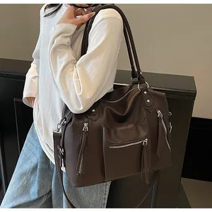 Dettaglio della grande borsa tote marrone scuro con tasche multiple a zip e doppi manici