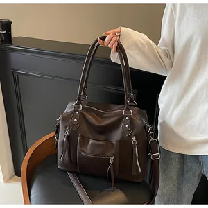 Dettaglio della borsa tote vintage marrone con grana in pelle e design multitasche