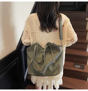 Detail of vintage green frosted tote bag with adjustable straps on a wooden staircase
