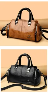 Detalle de bolsos Boston retro en cuero negro y marrón con logotipos metálicos de canguro