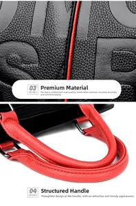 Detail of embossed lettering on black pebble leather bag with red padded handles