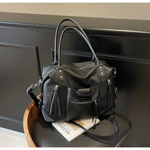 Dettaglio della borsa tote in pelle nera a grana litchi con tasche a zip color argento