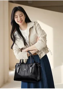 Détail du sac à main en cuir noir avec logo kangourou argenté et finitions métalliques