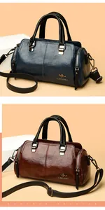 Detalle de bolsos Boston de cuero encerado en azul y marrón con logo de canguro