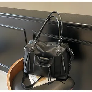 Dettaglio della borsa tote in pelle martellata nera con diverse tasche multifunzione