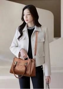 Gros plan d'un sac bandoulière vintage marron avec logo kangourou et détails dorés