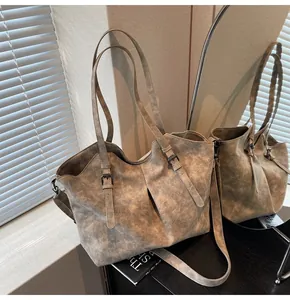 Detail of vintage matte tote bag showing distressed leather texture and buckle