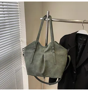 Detailed macro view of dark green tote bag with matte texture and decorative straps