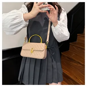 Dettaglio borsa trapuntata beige con manico in bambù e chiusura a girello dorata