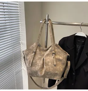 Detail of taupe vintage tote bag with adjustable metal buckle straps and matte texture