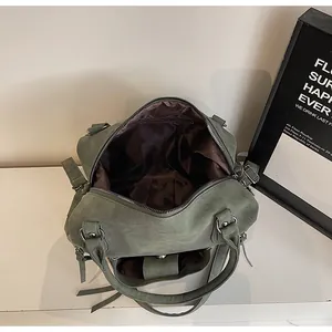 Top view showing the spacious dark green suede tote interior and zip compartment