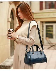 Detalle del bolso Boston de cuero texturizado azul oscuro con logo de canguro dorado