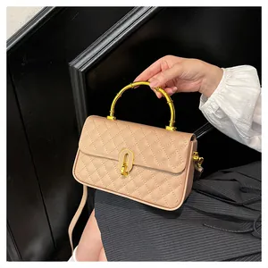 Dettaglio della borsa in pelle trapuntata con elegante manico in bambù dorato e chiusura