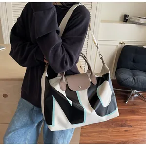 Detailed view of the large capacity canvas tote bag worn on shoulder by a model
