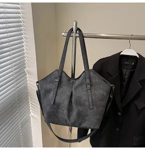 Detail view of large charcoal grey matte tote bag with adjustable shoulder strap and wings