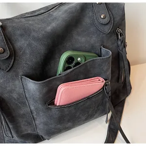 Detail view of large retro tote bag with functional pockets and silver rivet accents