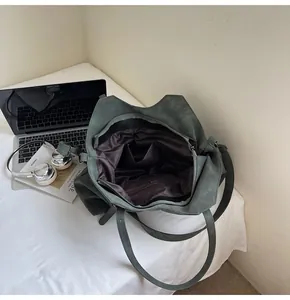 Detail of spacious dark green tote bag interior with multiple organizational pockets
