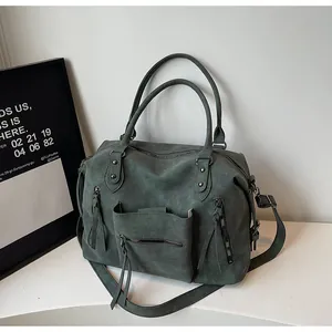 Close-up of deep green tote bag showing matte texture and functional double zipper pockets